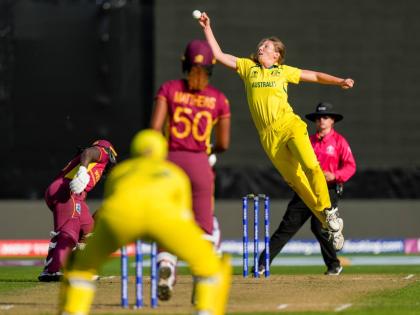 Darcie Brown of Australia (second right) attempts to field off her own bowling to the West Indies’ Hayley Matthews during the first semifinal match of the Women’s Cricket World Cup in Wellington, New Zealand on Wednesday, March 30, 2022. 