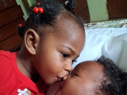 Big sister Arielle kisses ‘Boy’, her nickname for little sister Anna-Olivia.