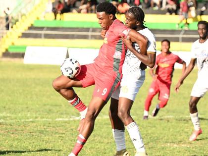 Montego Bay United’s Jahmari Clarke shields  the ball from Cavalier’s Jahdiel Russell during their Jamaica Premier League match at Jarrett Park in Montego Bay yesterday. Montego Bay won 3-1.