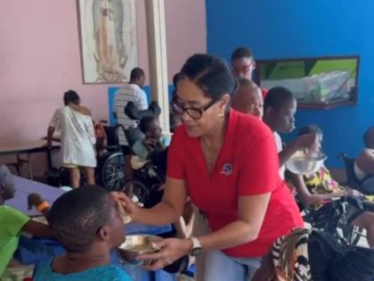 Rachel Matthews, Shipco Transport’s regional manager for the Caribbean, feeds one of the residents while at the Jacob’s Well residential care facility for women.