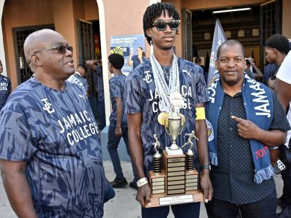 From left: Wayne Robinson, principal of Jamaica College, Michael-Andre Edwards, captain, and Duane Johnson, head coach, join in the celebration of the school’s ISSA/GraceKennedy Boys and Girls’ Athletics Championships at the institution’s Old Hope Ro