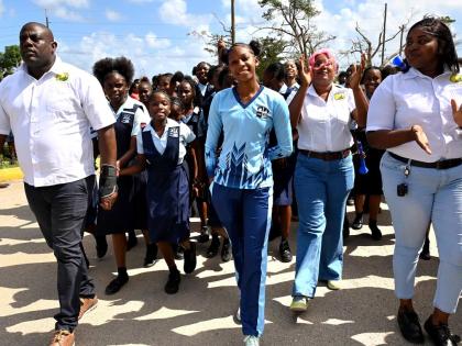 Shanoya Douglas (centre) enters Holland High School grounds in Trelawny to a hero’s welcome on Monday, following her record-breaking performance at the 2026 ISSA GraceKennedy Boys’ and Girls’ Athletics Championships.