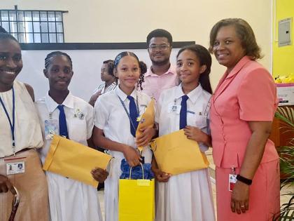 First-place winners Amia Thomas, Miaya Stewart and Zhanna Whyte of Immaculate Conception High School share a photo with their teacher, Danielle Francis (left), and Professor Marcia Roye (right), associate dean for Graduate Studies and Research in the Facul