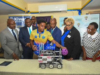 Bryan Smart (3rd right), chief engineer, Robotics Club, Ardenne High School, provides a demonstration of the skills of the robot built by club members during the launch of the UTech Kiwanis STEM Education Project on Monday, March 23 at Ardenne High School.