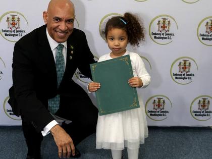  Jamaica’s Ambassador to the United States, Major General (Ret’d) Antony Anderson presents four-year-old Corey Webber Cummings, Jamaica’s newest citizen with an official letter of recognition   marking her formal entry into Jamaican citizenship.