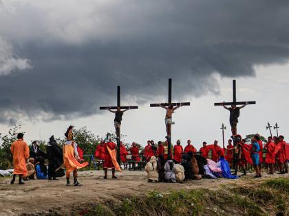 Ruben Enaje (centre) remains on the cross flanked by two other devotees during a reenactment of Jesus Christ’s sufferings as part of Good Friday rituals in San Pedro Cutud, north of Manila, Philippines.