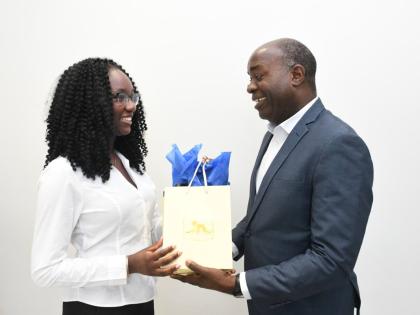 Jadyn Sinclair (left), winner of the 2025 Union of Jamaican Alumni Associations Essay Competition, accepts a gift from Hugh Miller, acting general manager of the JN Financial Group, at the JN Group Corporate Offices recently. The occasion was a courtesy ca