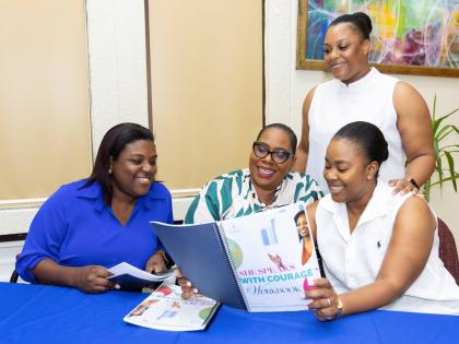 Team members from Flow Jamaica engage with the workshop material. Sudean Brown, client relations executive, stands behind her colleagues (from left) Donna Allison, sales manager, retail stores; Javana Francis, sales manager, residential sales; and Chevanic