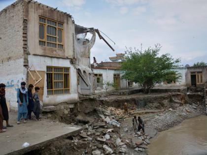 Residents inspect a building that partially collapsed due to heavy flooding in Jalalabad, Afghanistan, Saturday, April 4, 2026. (AP Photo/Wahidullah Kakar)