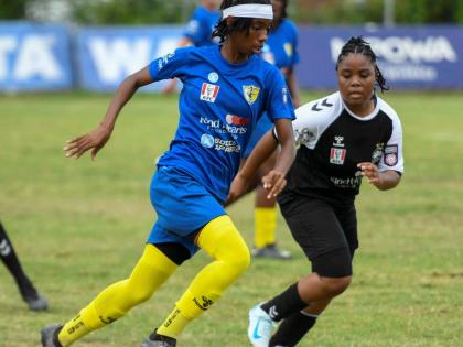 Antoine Lodge/Photographer 
Real Mona’s Olivia Ashbourne (left) tries to drive past Cavalier SC’s Torri-Ann Harris during their Jamaica Women’s Premier League fixture at the Alpha Institute yesterday.