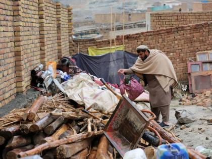 A man searches through items piled up at a house damaged by an earthquake in the village of Ittefaq, on the outskirts of Kabul, Afghanistan.