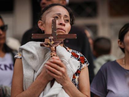 A devotee holds a cross during a Good Friday procession in the Ciudad Bolivar neighbourhood of Bogota, Colombia.