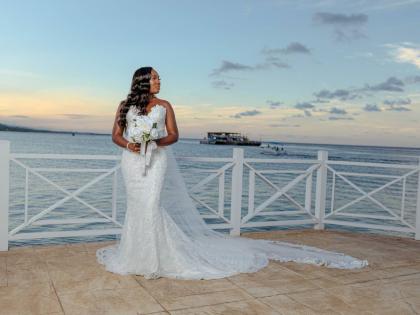 Chelsea radiates elegance as she holds a bouquet of white roses, wearing a gown from New York-based Pantora Bridal, owned by Jamaican-American designer Andrea Pitter.