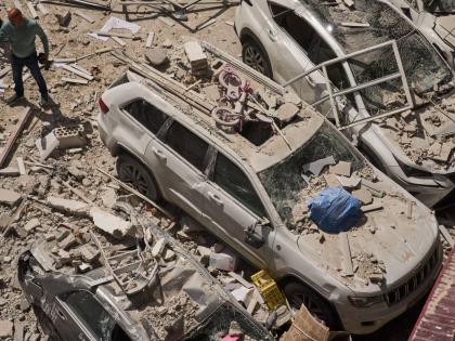A man inspects the damage to cars and an apartment building struck by an Iranian missile in Ramat Gan, Israel on April 6, 2026. (AP Photo/Oded Balilty)