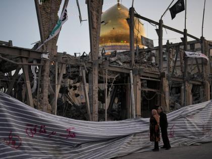 Pedestrians look at a destroyed building within the Grand Hosseiniyeh, with the mosque visible in the background, which officials at the site say was hit by US-Israeli airstrikes  in Zanjan, Iran,  on Saturday, April 4.  AP 