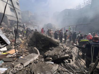 Rescue workers search for victims at the site of an Israeli airstrike that hit a crowded neighbourhood south of Beirut, Lebanon, Sunday, April 5, 2026. 