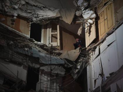 A woman stands at a destroyed apartment on a building that was hit in an Israeli airstrike in central Beirut, Lebanon, Wednesday, April 8, 2026. (AP Photo/Emilio Morenatti)