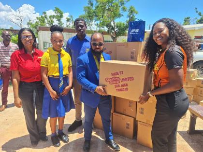 Shantell Hill-Afonso (right), marketing manager at Sunshine Snacks, presents an assortment of snacks to Audley Feare, principal of Aberdeen High School in St Elizabeth. Sharing the moment are (from left) Marilyn McDonald, manager of community renewal at th