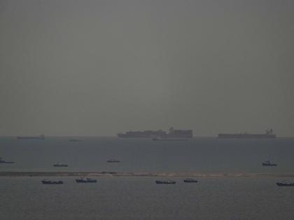 Fishing boats dot the sea as cargo ships, in the background, sail through the Arabian Gulf toward the Strait of Hormuz off the United Arab Emirates, Friday, March 27, 2026. (AP Photo)