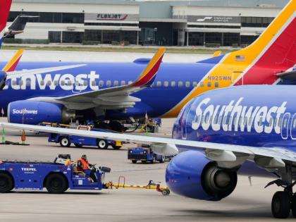 Flight line workers push a Southwest Airlines aircraft away from a gate at Love Field Airport in Dallas, Monday, March 16, 2026. (AP Photo/Tony Gutierrez)