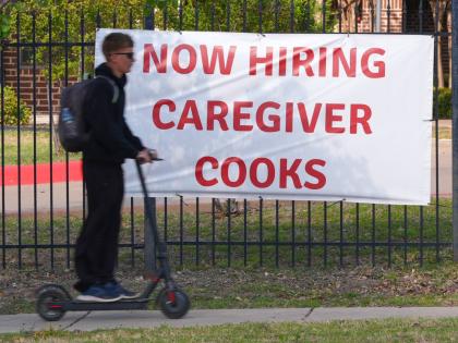 AP 
A ‘now hiring’ sign sits by the sidewalk as a rider on a scooter passes in Garland, Texas, Monday, March 23. 