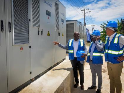 Minister of Health and Wellness, Dr Christopher Tufton (right), and CEO of the National Health Fund (NHF), Everton Anderson (centre), listen as NHF director of institutional benefits, projects and maintenance, Richard Allen, explains components of the sola