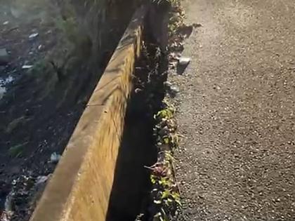 A wall on the approach to the bridge breaking away from the road surface. 