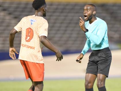 
Referee Oshane Nation (right) remonstrates with Roino Gordon during the Manning Cup final against Hydel High School at the National Stadium in 2023.