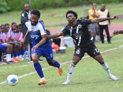 Alex Marshall (left) of Mount Pleasant dribbles away from Cavalier’s Kimarly Scott  during their Jamaica Premier League match at the Stadium East field yesterday. Mount Pleasant won 3-1.