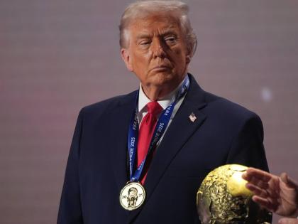 President Donald Trump stands on stage next to the FIFA World Cup after receiving the FIFA Peace Prize during the draw for the 2026 football World Cup at the Kennedy Center in Washington on Decmber 5, 2025. 