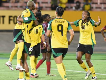 Jamaica’s Deneisha Blackwood (left) celebrates with teammates after she scored from the penalty spot to complete a 4-0 win for the Reggae Girlz in their Concacaf Women’s qualifier against Antigua and Barbuda at the National Stadium last night.