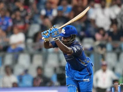 Mumbai Indians’ West Indian batsman Shefane Rutherford hits a boundary during the Indian Premier League cricket match between Mumbai Indians and Royal Challengers Bengaluru, in Mumbai, India, yesterday. Rutherford hit nine sixes in an unbeaten 31-ball 71