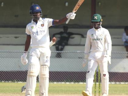 Barbados Pride batsman Kevin Wickham raises his bat after getting to 150 against the Jamaica Scorpions at Chedwin Park yesterday. Wicketkeeper Romaine Morris looks on.