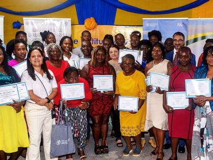 Participants in the Improving Rural Livelihoods through Resilient Agri-food Systems (IRL) Project, in the company of officials, display their certificates during the certification ceremony, held recently at the Spring Village Community Centre in St. Cather