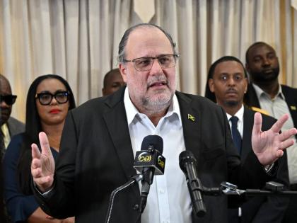 Surrounded by members of his team, Opposition Leader Mark Golding speaking at a press conference at the Office of the Leader of the Opposition on West Kings House Road in St Andrew on Tuesday.