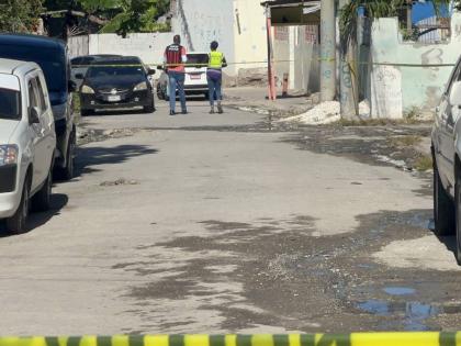 A police investigator and an investigator from the Independent Commission of Investigations (INDECOM) at the scene of a fatal police shooting in the Waltham area of St Andrew on April 15, 2026.