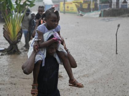Residents wade through a flooded street in the aftermath of Hurricane Melissa in Petit-Goave, Haiti, Thursday, Oct. 30, 2025. (AP Photo/Odelyn Joseph)