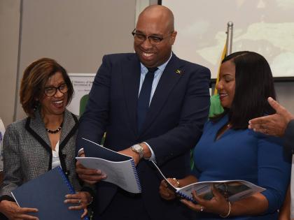 Delano Seiveright (centre), Minister of State in the ministry of Industry, Investments and Commerce, leafs through the Dangerous Drugs (Cannabis Licensing) (Interim) (Amendment) Regulations, 2025, with Sancia Bennett-Templer (left), Permanent Secretary in 