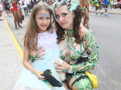 Eight-year-old Tessa Tupicov (left) and her sister, Scarlett Tupicov, pose for the camera during the Yard Mas Road March on Sunday. 