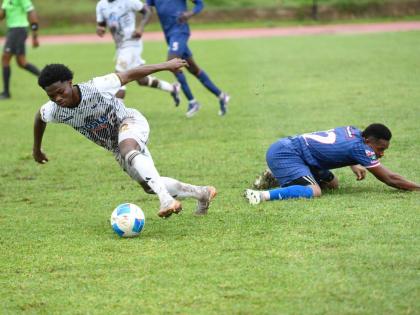 Cavalier FC’s Kimarly Scott dribbles away from Spaish Town Police’s Adrew Vanzie during their Jamaica Premier League football match at Stadium East yesterday. Cavalier won 3-0.