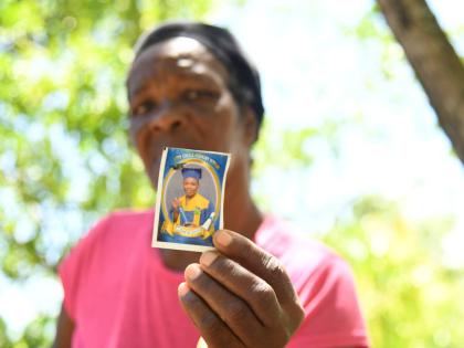 Vinnella Sutherland holds a photograph of her 13-year-old grandson, Kland Doyle, who was fatally stabbed, reportedly by a peer, on Monday in St Thomas. 
