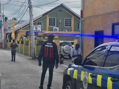 Crime scene officers outside the New Testament Church of God at Water Lane in Montego Bay, St James, yesterday, where a member of the church was shot dead.