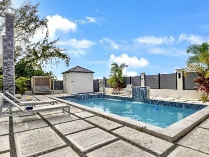 The backyard with a pool, hot tub, and waterfall, affording pleasure all year round.