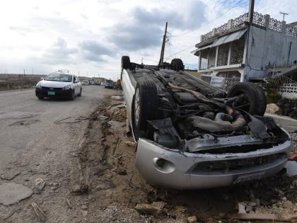 An overturned car among the rubble in Catherine Hall following the passage of Hurricane Melissa late last year.