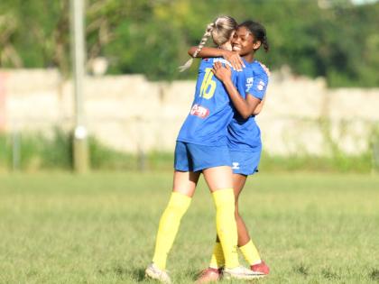 Monica Bosiljevac of Real Mona FC (left) is embraced by her teammate Alexia Evans after scoring a goal during the Jamaica Women’s Premier League fixture against UWI women’s FC at UWI Mona Bowl on Saturday.