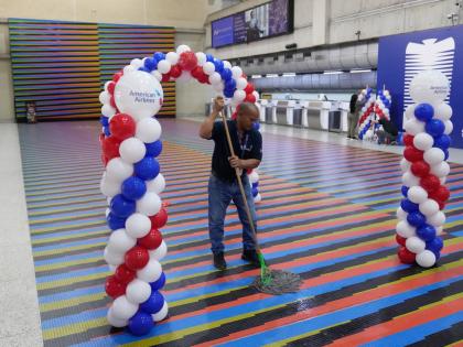 A worker cleans the check-in area ahead of the arrival of a US commercial flight at Simon Bolivar International Airport in Maiquetia, Venezuela, Thursday, April 30, 2026, as direct air service between the United States and Venezuela resumes after seven yea