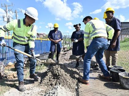 Rudolph Brown/Photographer
Caribbean Cement Company Limited Managing Director Jorge Martinez (left) and Group Managing Director of the Trinidad Cement Limited cluster, Francisco Aguilera (second right), take part in a demonstration with students at St Eliz