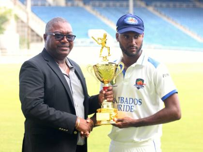 Barbados Pride captain Kragg Brathwaite (right) collects the bilateral series trophy from Jamaica Cricket Association CEO Courtney Francis at the end of the West Indies Championship match against Jamaica Scorpions at Sabina Park on Tuesday.
