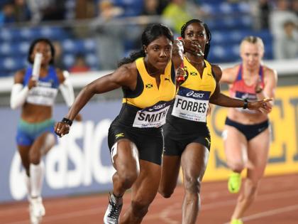 Jonielle Smith (left) receives the baton from Shashalee Forbes in the women’s 4x100-metre relay heats at the 2021  World Athletics Relays in Yokohama, Japan.