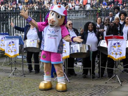 Finnie, the official mascot for the Glasgow 2026 Commonwealth Games, poses for a photo with the members of Melodians Steel Orchestra at the Commonwealth Day Service of Celebration at Westminster Abbey in London on March 9. 